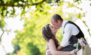 bride-and-groom-kiss-on-fence